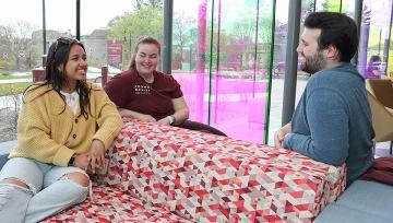 Students talking happily on couches in Horace Mann building